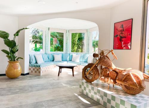 a living room with a couch and a motorcycle statue at Kyriad Cannes - Mandelieu in Cannes