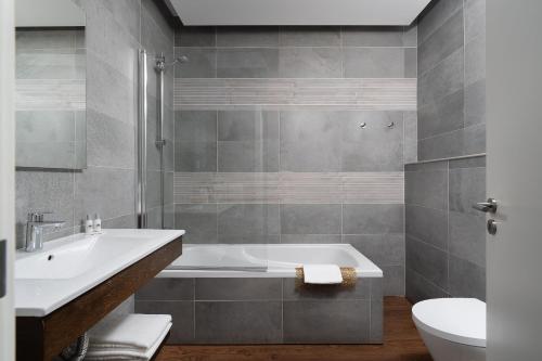 Un baño con bañera, lavabo e inodoro. en Clube Vilarosa, en Portimão
