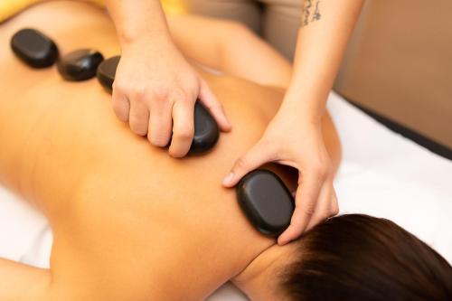 a woman with black massage pads on her body at Hotel Kanajt in Punat