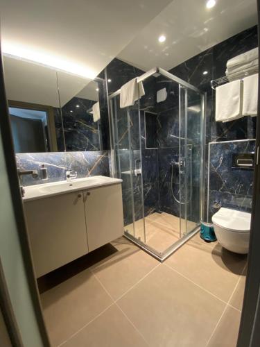 a bathroom with a shower and a sink and a toilet at Şenyıldız Hotel in Izmir