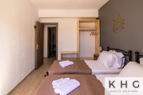 2 letti in camera d'albergo con asciugamani di Skoumas villa surrounded by Olive trees! a Vlachata