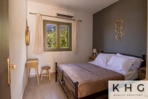 a bedroom with a bed and a window at Skoumas villa surrounded by Olive trees! in Vlachata