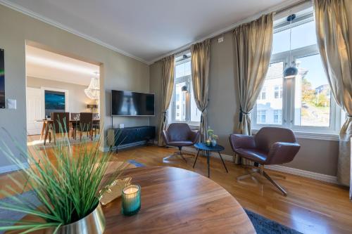Enter Tromsø - 3 Bedroom Luxury Apartment في ترومسو: غرفة معيشة مع طاولة وكراسي