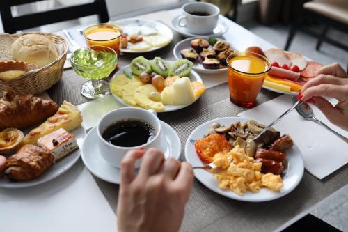 - une table avec des assiettes de petit-déjeuner dans l'établissement Urban Hotel Estacao, à Braga