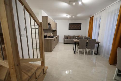ein Wohnzimmer und eine Küche mit einem Tisch und Stühlen in der Unterkunft ZABRZE Apartamenty Kościuszki 30 in Zabrze