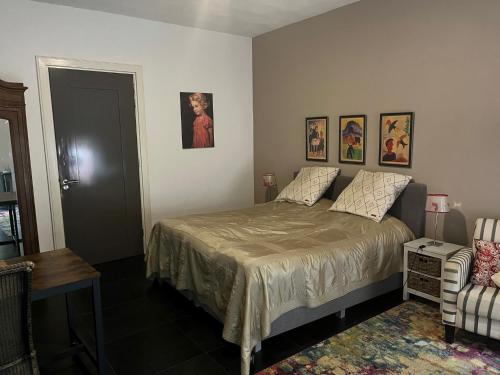 a bedroom with a bed and pictures on the wall at De Hiddinghhoeve in Onstwedde