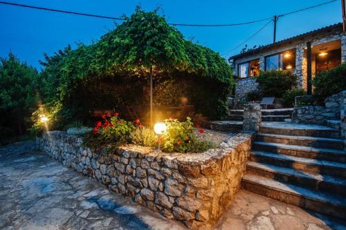 a stone retaining wall with stairs and a house at Villa Lily Comfortable holiday residence in Veli Iž