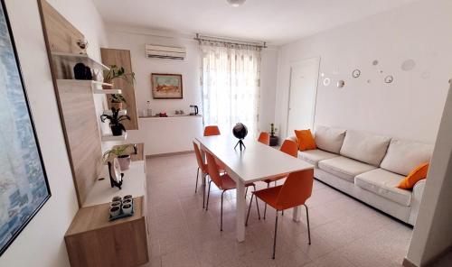 sala de estar con mesa y sofá en La Mandronia B&B en Alghero