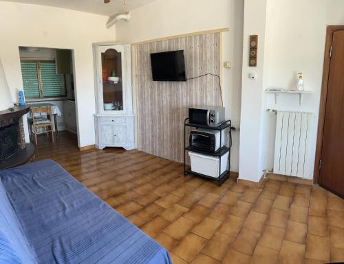 Habitación con cama y TV en la pared. en Casa Caterina- Pratoranieri Follonica, en Follonica