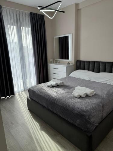 a bedroom with a bed with two towels on it at SC Tirana Centre Apartment in Tirana