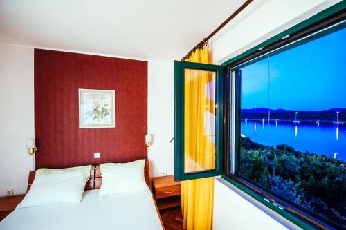 ヴェリ・イシュにあるVilla Lilyのベッドルーム1室(水辺の景色を望む大きな窓付)