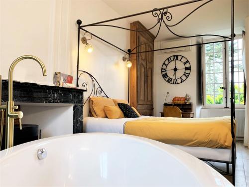 two beds in a room with a bath tub at LE BAS CHITRAY in Ménil