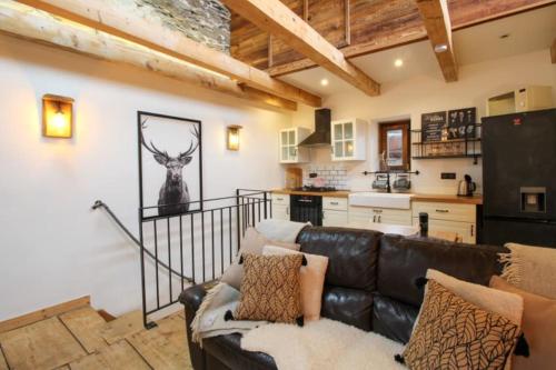 un salon avec un canapé en cuir et une cuisine dans l'établissement Charmante maison de hameau traditionnel montagnard, à Saint-Marcel
