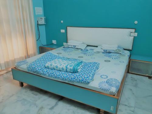 een bed in een kamer met een blauwe muur bij LAVISH Fully Furnished HOMESTAY - ISH, Atithya with various free amenities in Lucknow, INDIA in Lucknow