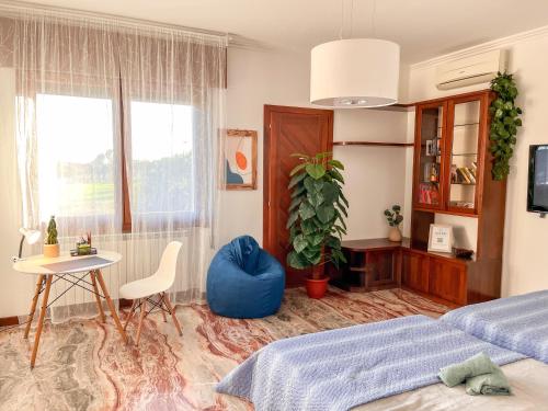 een slaapkamer met een bed, een tafel en een stoel bij Ornella's apartment - Relax near Venice 