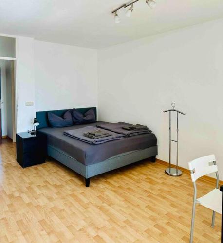 a bedroom with a bed and a wooden floor at Schwabing-Studio great sunset view & balcony in Munich