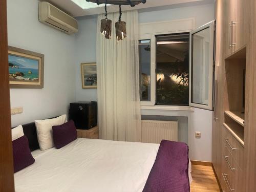a bedroom with a white bed and a window at Eleonora's Hidden Gem in Athens