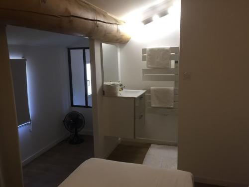 une salle de bain blanche avec un lavabo et un miroir dans l'établissement Mas du Soleil, à Caumont-sur-Durance