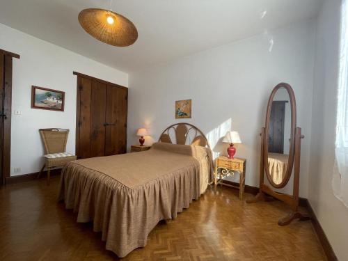 ein Schlafzimmer mit einem Bett und einem großen Spiegel in der Unterkunft Mendiko-lorea in Saint-Pée-sur-Nivelle