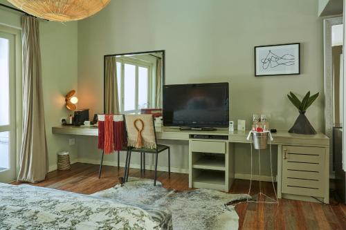 a bedroom with a desk with a television and a mirror at The Robertson Small Hotel and Spa by The Living Journey Collection in Robertson