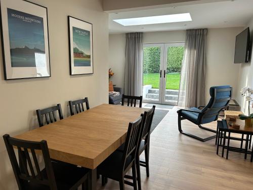a dining room with a wooden table and chairs at Pine View Holiday Home in Newcastle
