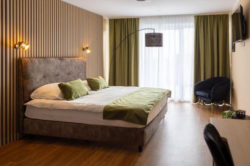 Hotel Dolenjc في نوفو ميستو: غرفة نوم فيها سرير وكرسي