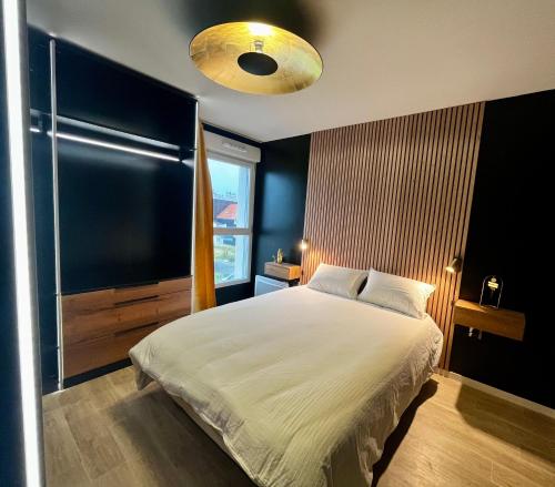 a bedroom with a bed with a black wall at Appartement de standing avec parking privé in Cherbourg en Cotentin