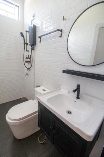 a bathroom with a sink and a toilet and a mirror at Romi Homestay Wakaf Tapai in Marang