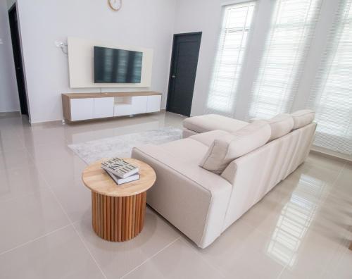 Sala de estar blanca con sofá blanco y mesa en Romi Homestay Wakaf Tapai en Marang