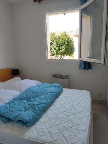 - une chambre avec un lit doté d'une couverture bleue dans l'établissement Maison a louer dans village de vacances, à Pierrefiche