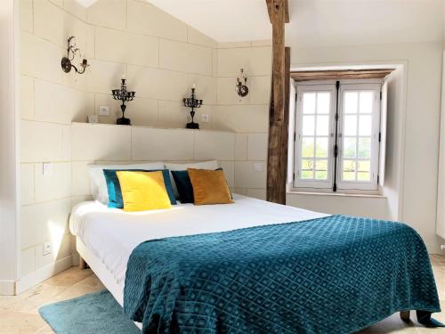 a bedroom with a bed with a blue blanket on it at LE BAS CHITRAY in Ménil