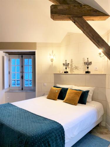 a bedroom with a large white bed with yellow pillows at LE BAS CHITRAY in Ménil
