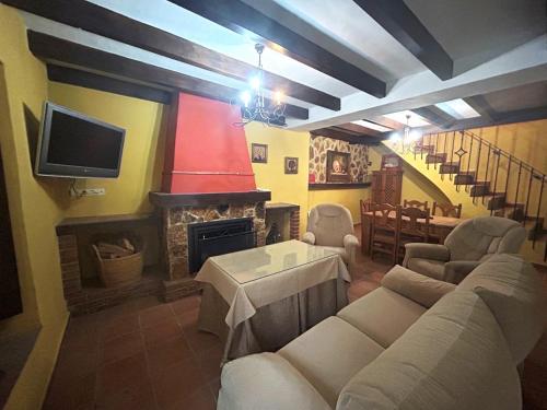 a living room with couches and a tv and a fireplace at Casa Gomez in Gaucín