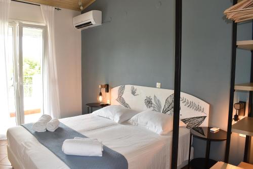 a bedroom with a bed with towels on it at Simatos αpARTments & Studios in Lassi