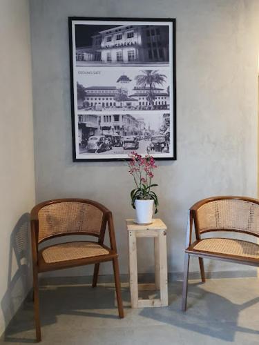 Deux chaises et une table avec une plante en pot sur celle-ci dans l'établissement The Cluster Harris, à Cimahi