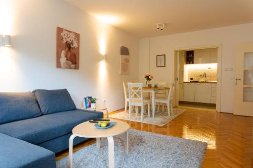 a living room with a blue couch and a table at Apartman Nena in Valjevo