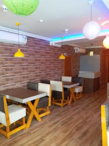 a dining room with tables and chairs and a brick wall at Hotel Mahalaxmi Indo Myanmar in Guwahati