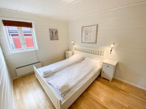 um quarto com uma grande cama branca num quarto em Tregde Ferie em Mandal