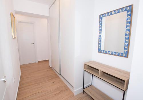 カルプにあるEdificio Calpemarの鏡と木製のテーブルが備わる廊下
