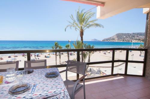 a table on a balcony with a view of the beach at Edificio Calpemar in Calpe