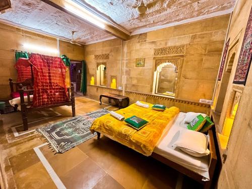 1 dormitorio con 1 cama con edredón amarillo en Hotel Oasis Haveli, en Jaisalmer