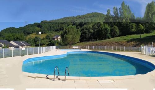 une grande piscine bleue dans une cour dans l'établissement Maison a louer dans village de vacances, à Pierrefiche