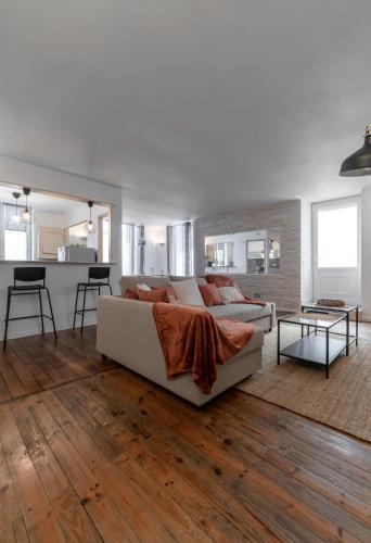 un salon avec un canapé blanc et une cuisine dans l'établissement Le Duplex - Grand appartement centre ville, à Vichy