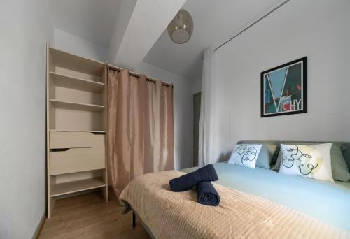 une chambre avec un lit avec une couverture bleue dans l'établissement Le Duplex - Grand appartement centre ville, à Vichy