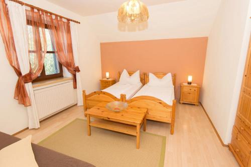Schlafzimmer mit einem Bett, einem Tisch und einem Fenster in der Unterkunft Naturparkbauernhof Pöltl in Pöllau