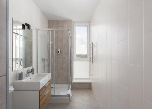 a white bathroom with a shower and a sink at Nyvky Residence in Kyiv