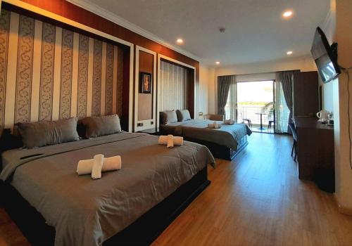 a hotel room with two beds and a television at 4 RIVERS HOTEL in Phnom Penh