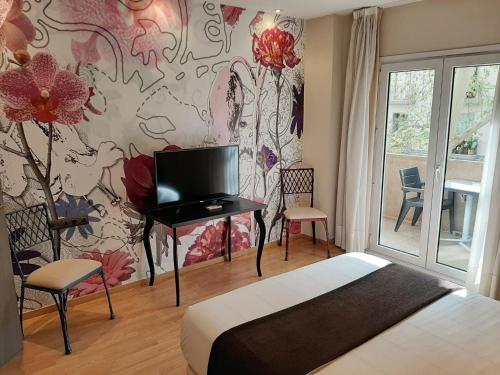 1 dormitorio con 1 cama y una pared con flores en Vernisa, en Xàtiva