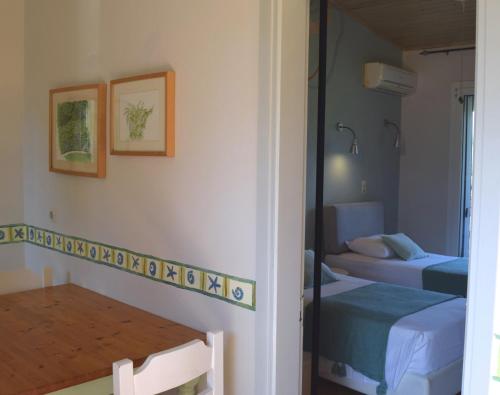 a room with two beds and a table and a mirror at Simatos αpARTments & Studios in Lassi