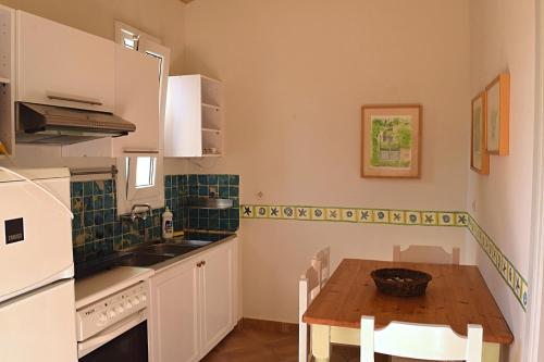 a kitchen with a wooden table and a sink at Simatos αpARTments & Studios in Lassi